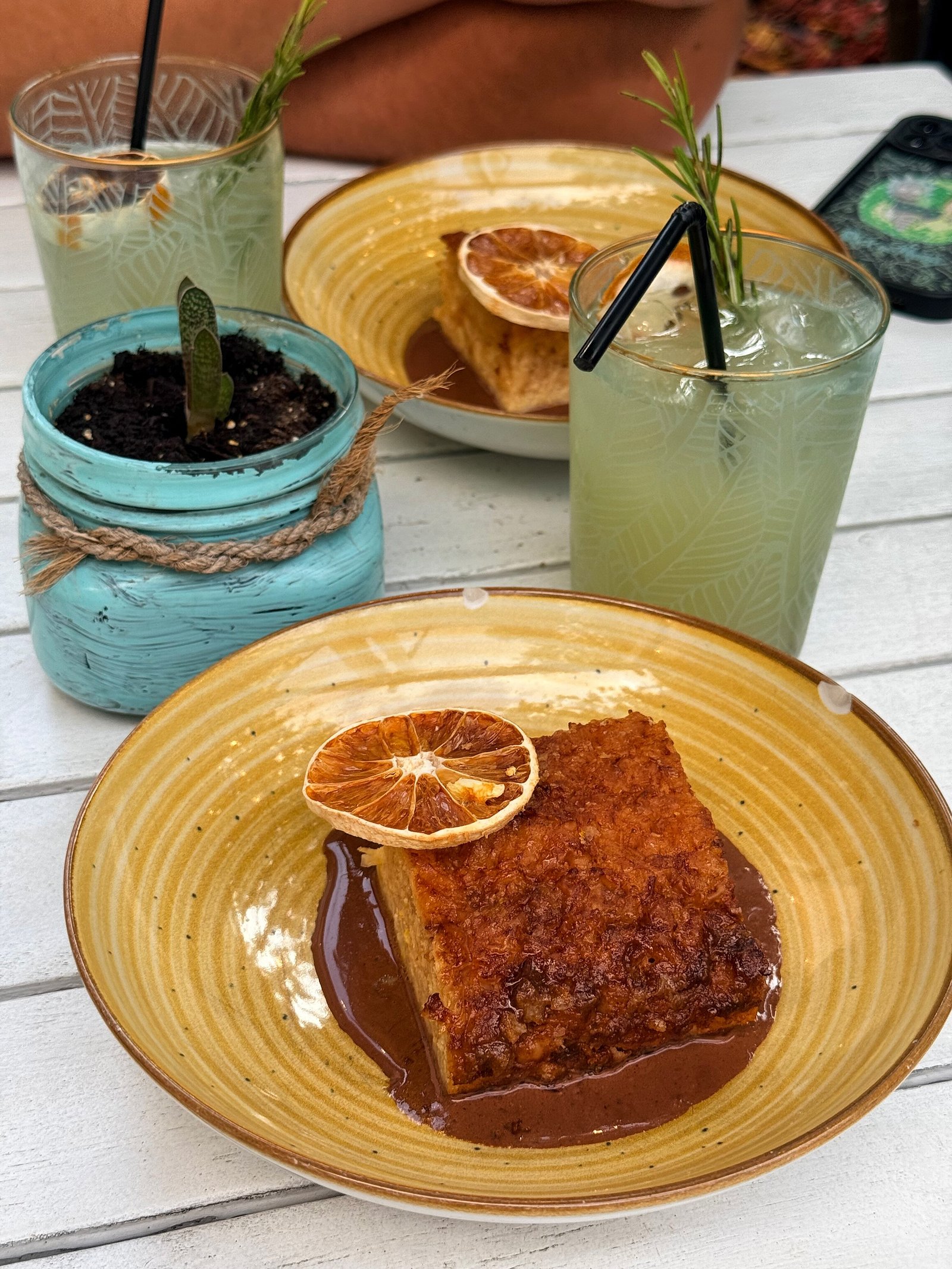 Desert servit pe farfurie, alături de un cocktail
